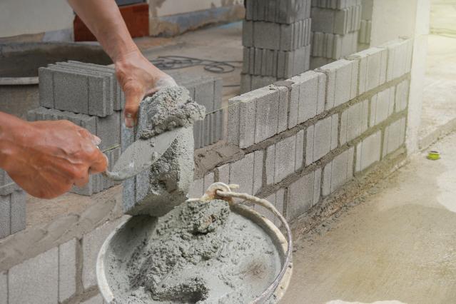 bricklayer_scooping_mixed_mortar_on_brick